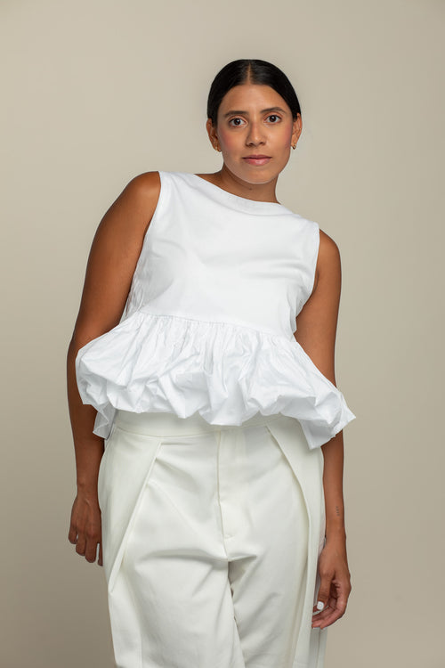 Top peplum de algodón blanco hueso combinado como look completo de la colección Esencia de azor.